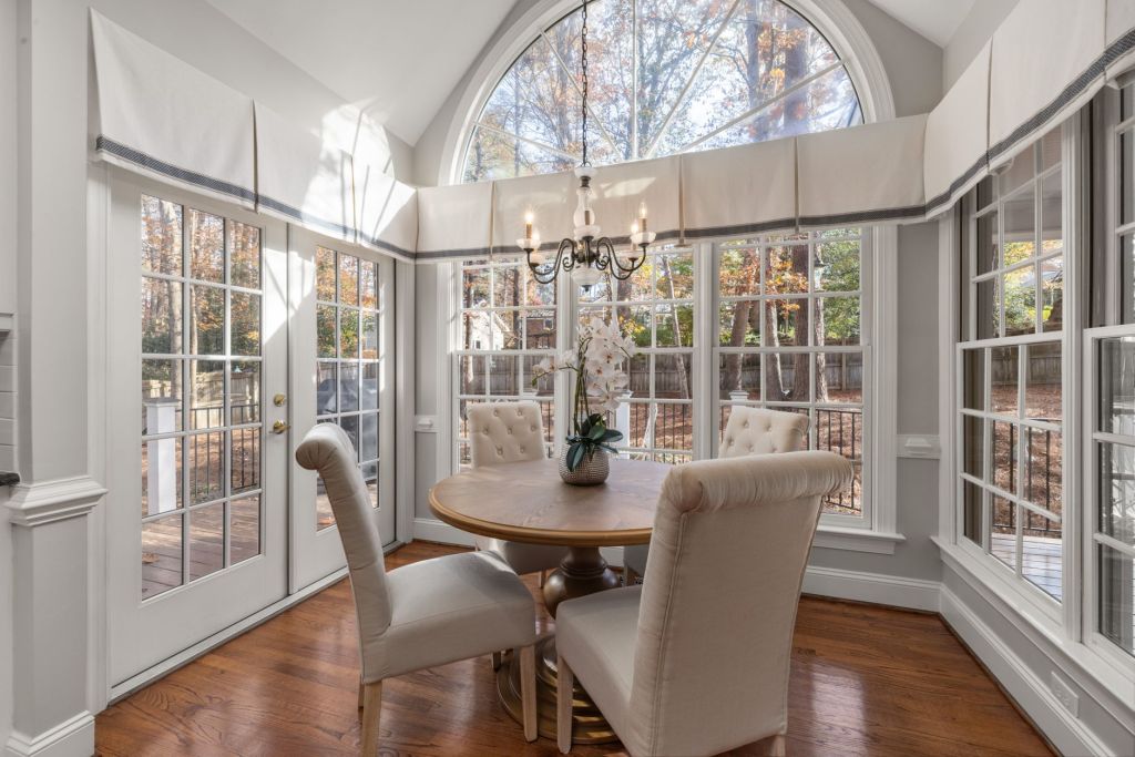 bright dining room with chandelier and large windows